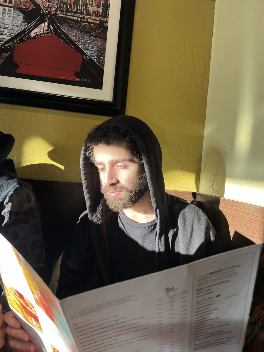 Ahmad Abu-Hattab — Engineering Physics student at McMaster University, reading at a restaurant in Toronto, Ontario